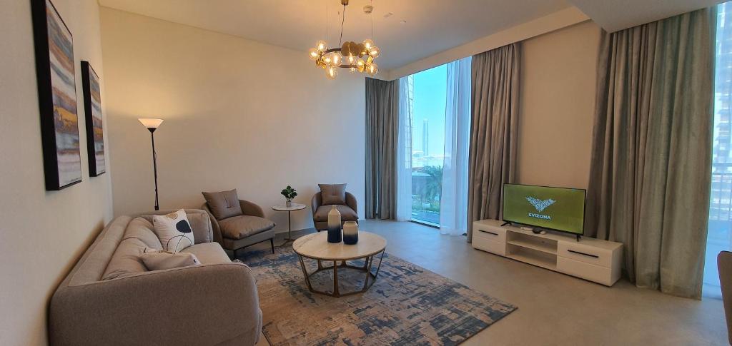 SVIZONA Premium 2 Bed I Panoramic Creek Views في دبي: غرفة معيشة مع أريكة وتلفزيون