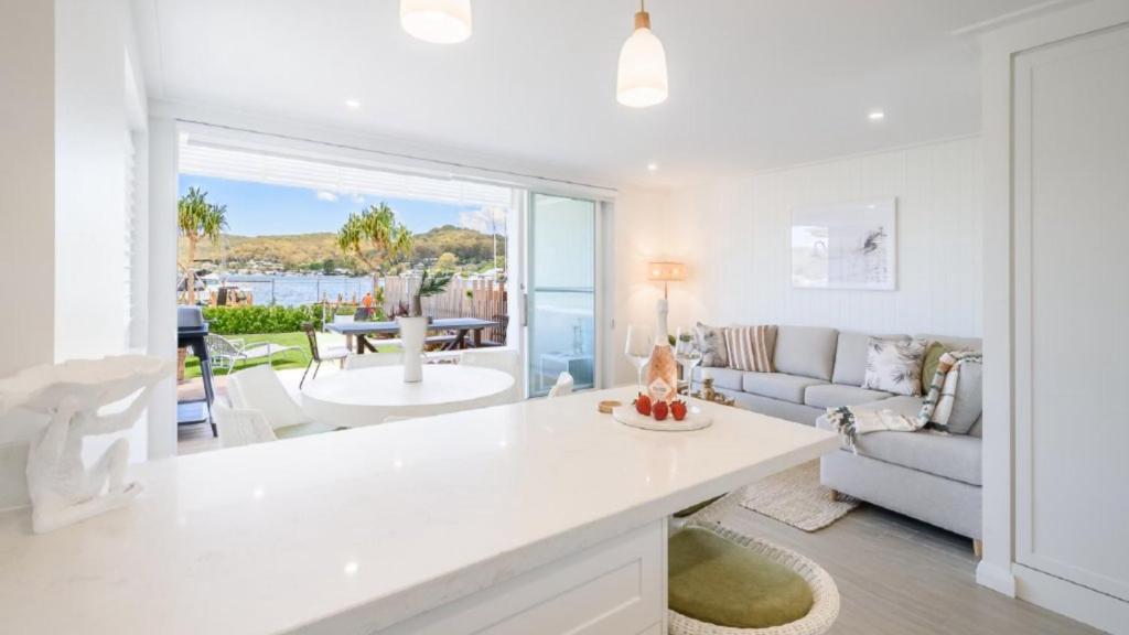 a kitchen and living room with a view of the ocean at Watersea By The Bay Unit 2, waterfront, walk to shop&restaurants in Umina