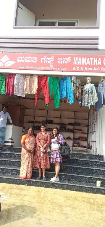 three women standing in front of a clothing store at Mamatha Guest inn in Hampi