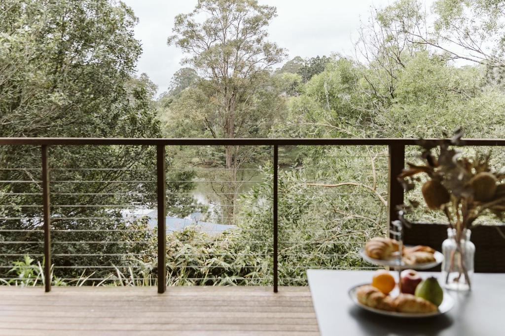 two plates of fruit on a table on a balcony at "On Burgum Pond" Cottages in Maleny