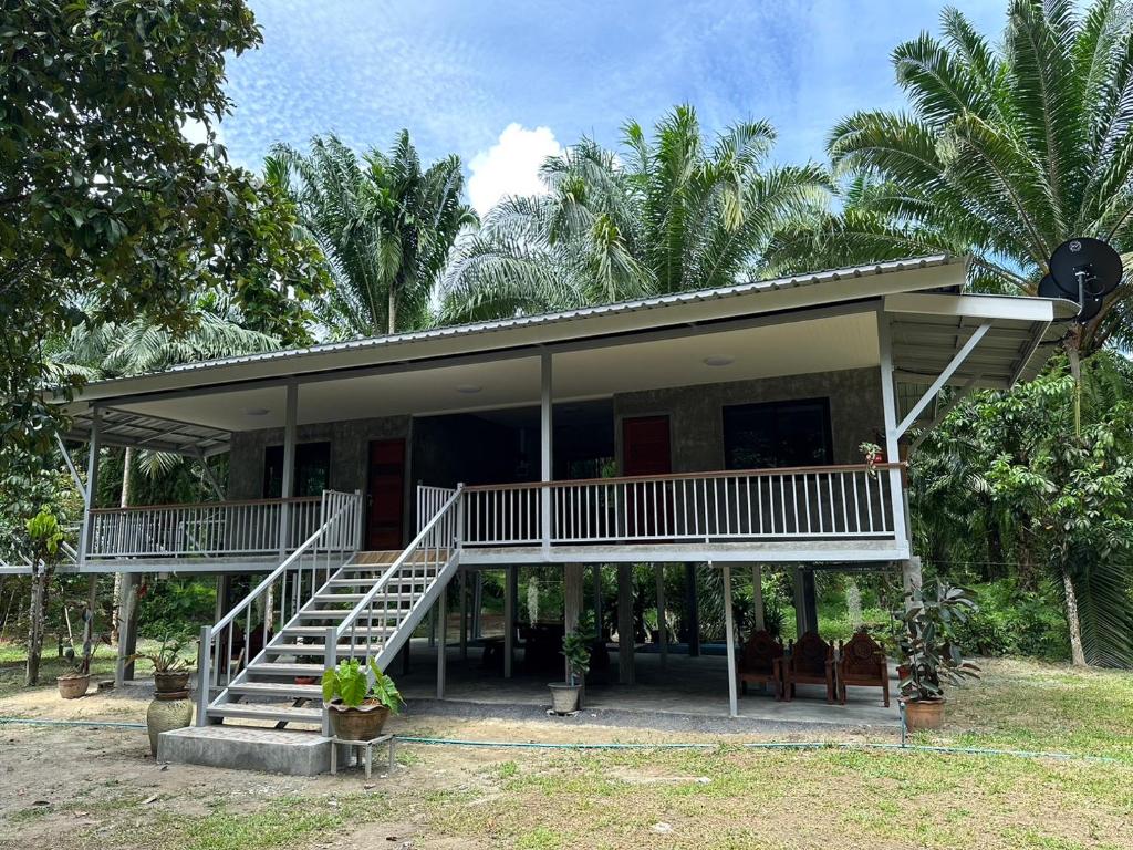 una casa con una escalera delante de ella en บ้านสวนริมธาร โฮมสเตย์ ท้ายเหมือง พังงา 