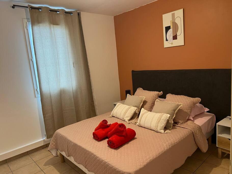 uma cama com dois bichos de peluche vermelhos em Lil'appart em Saint-Denis