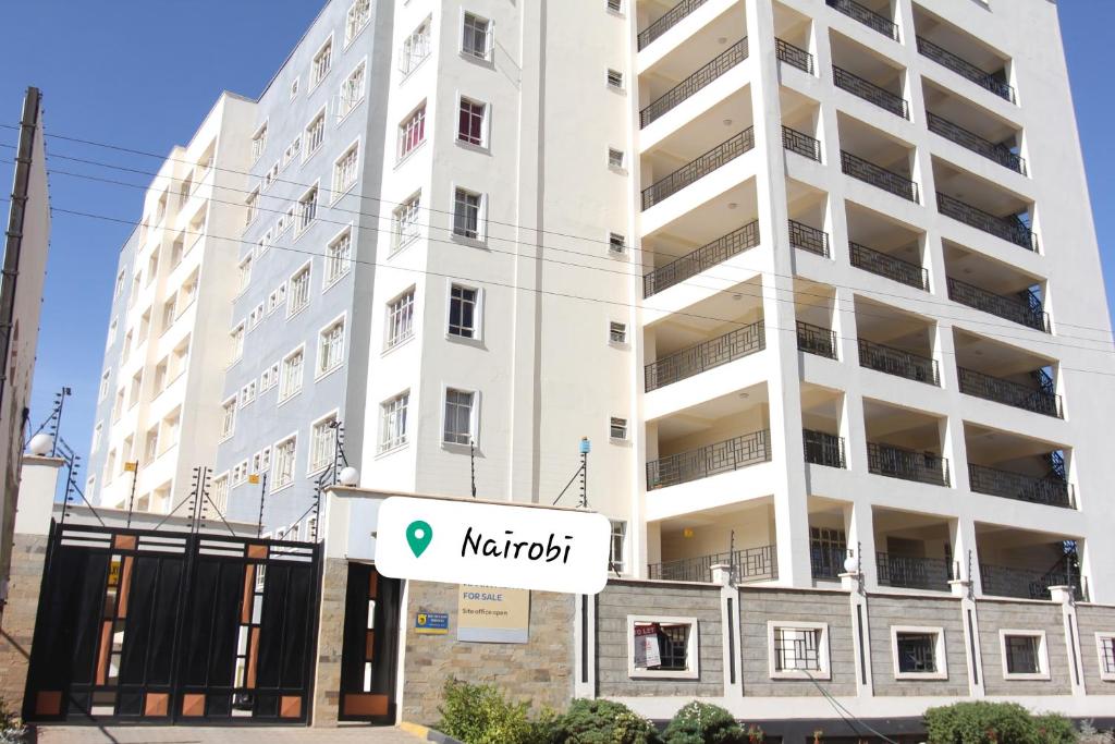 een wit gebouw met een bord ervoor bij NLS in Nairobi