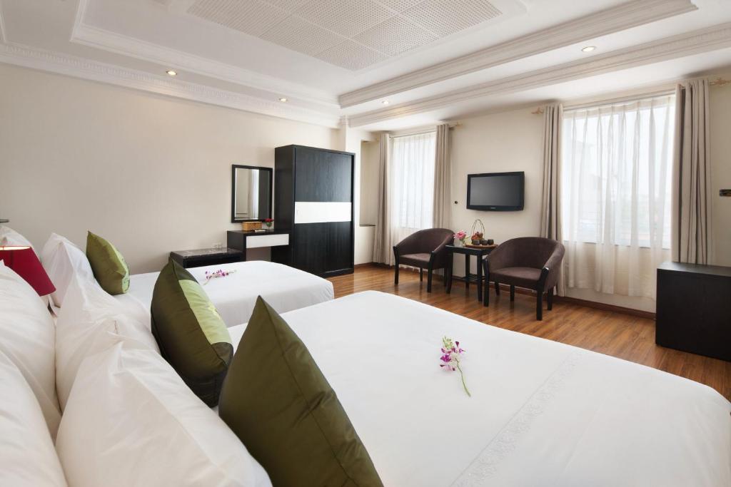 Cette chambre d'hôtel dispose d'un canapé blanc et d'une télévision. dans l'établissement Serenity Villa Hotel, à Hanoï