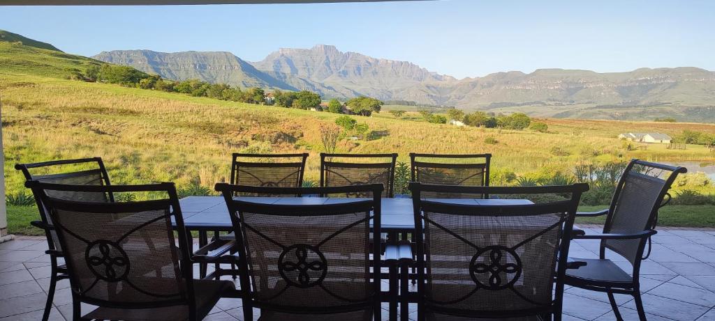 a group of chairs and a table with mountains in the background at Sunset place, Cathkin Estate in Ardmore