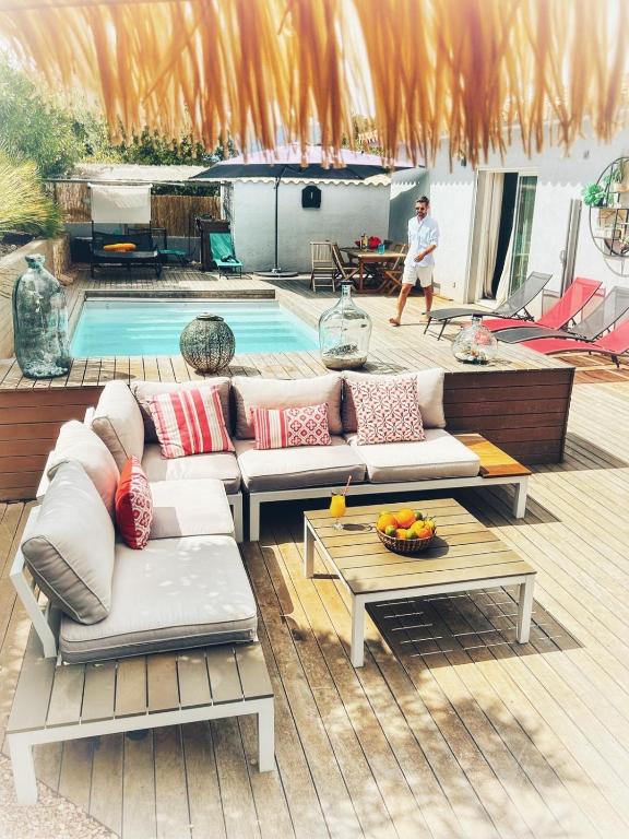 une terrasse avec un canapé, des tables et une piscine dans l'établissement Villa Orethaga Piscine 10 pers porto Vecchio, à Porto-Vecchio