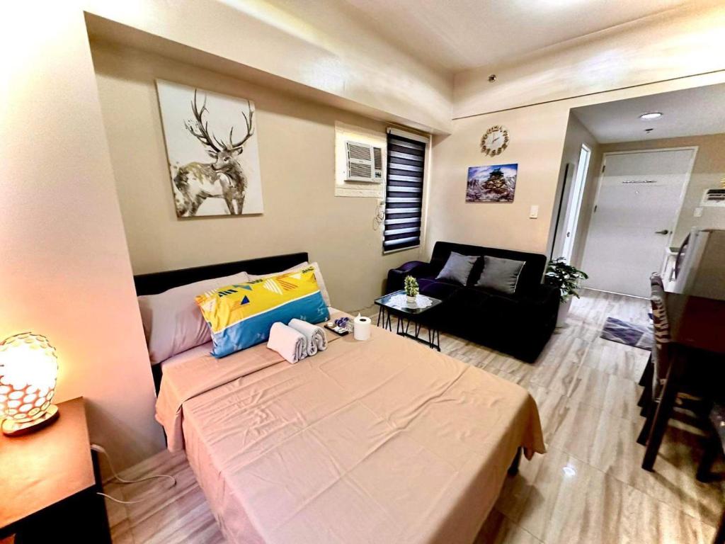 een kleine woonkamer met een bed en een bank bij Across Sm City Cebu Sunvida Tower Studio Unit in Cebu City