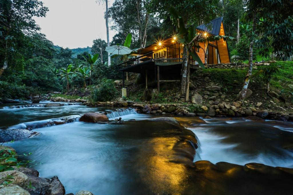 清邁的住宿－Virgin River @Mae Wan，灯火通明的房子前的河流