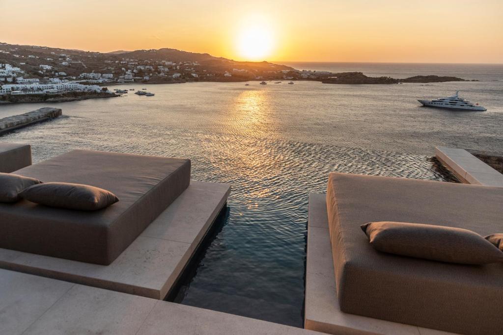 a view of the ocean from a resort with beds at The Skyvilla Mykonos - A Landmark Property with Breathtaking Views of the Psarou bay in Mikonos