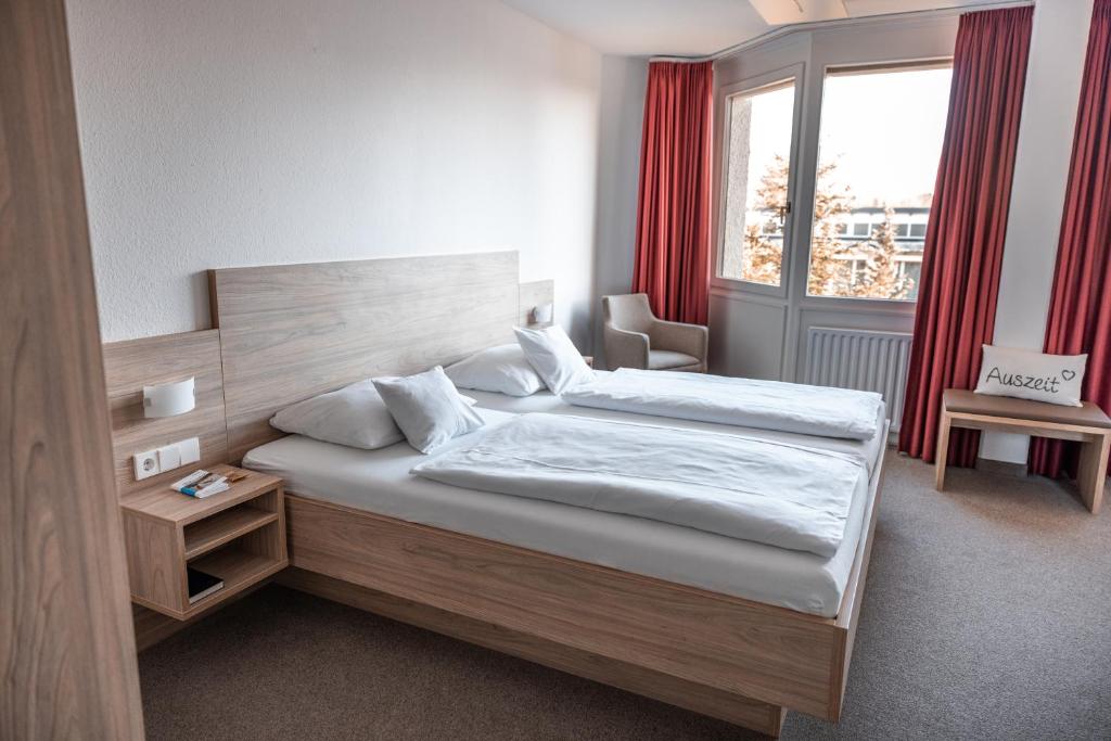 a bedroom with two beds and a window at Hotel am Schlossberg in Herrenberg