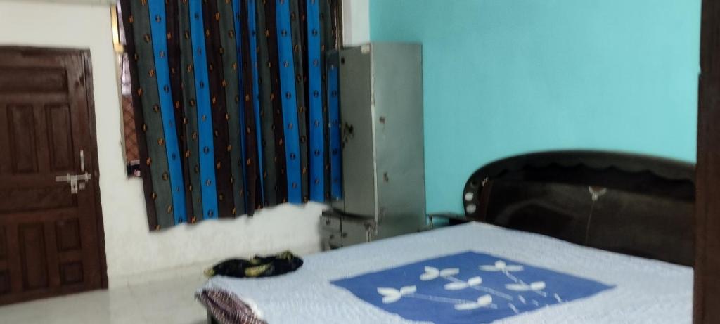 um quarto com uma cama com uma parede azul em Gupta's house em Dindori