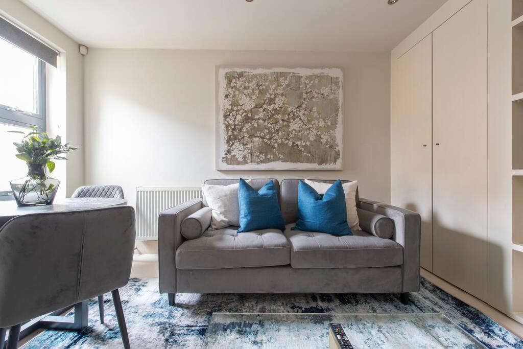 a living room with a couch with blue pillows at Elegant 1-BR Retreat in Ilford Centre in Ilford