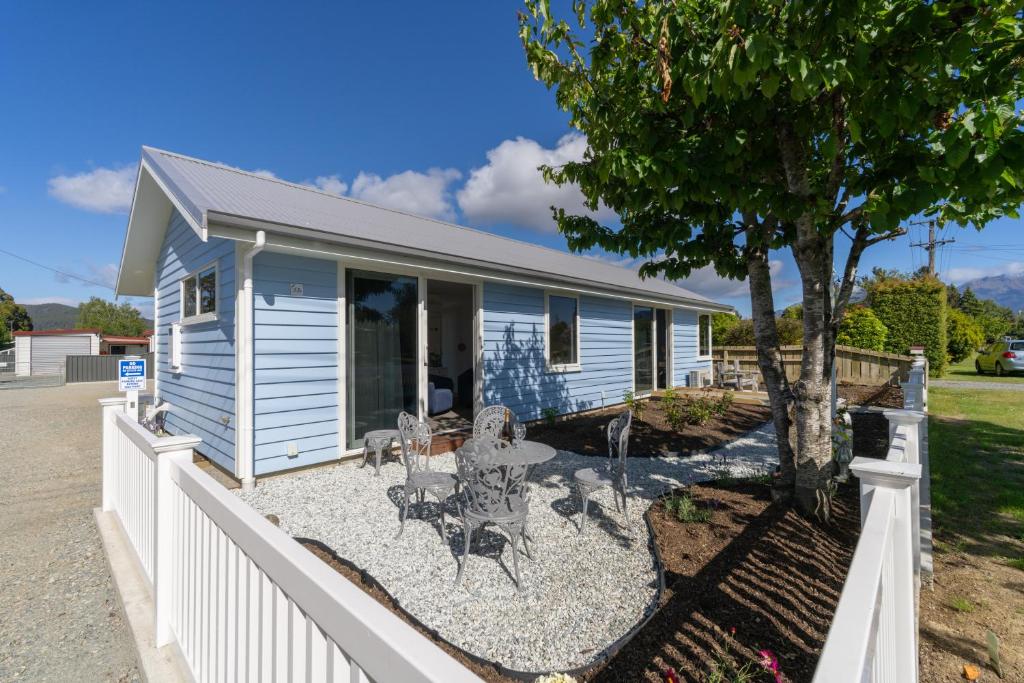 a house with a white fence in front of it at The Mayflower Cottage in Te Anau