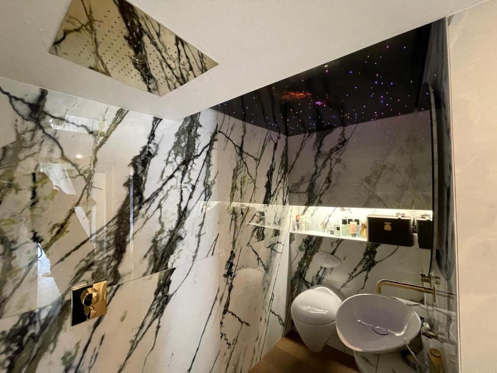 a bathroom with a black and white marble wall at Mazot Agora Suite - Pop-Up Gallery Experience Suite in Salvan