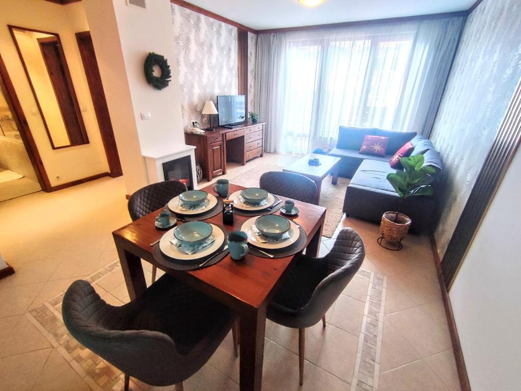 a living room with a table and chairs and a couch at Private 1bedroom apartment in SPA Resort in Bansko
