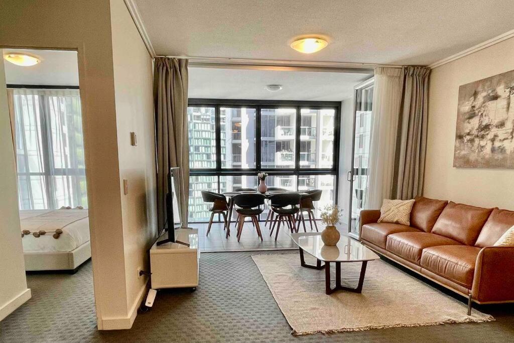 a living room with a couch and a table at Luxury City Center King Bed Apartment and Study in Brisbane