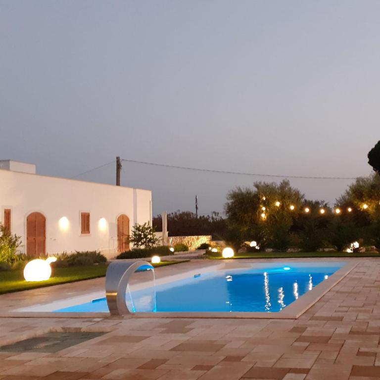 a swimming pool in front of a house at night at Pool & Private Parking DONNA LINA in Conversano