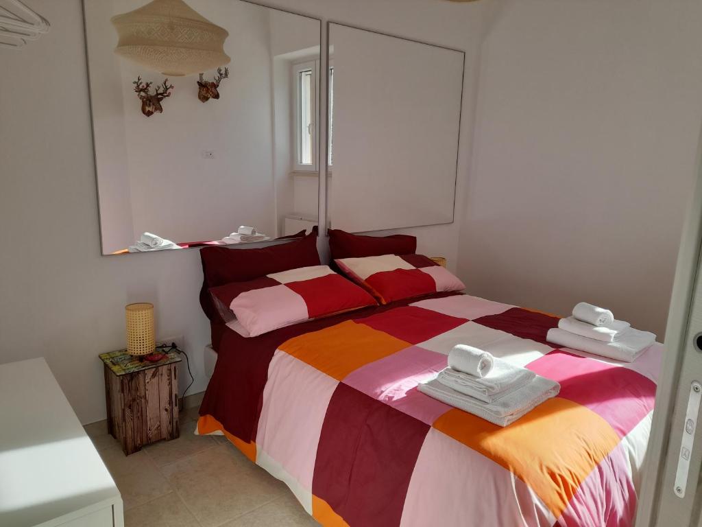 1 dormitorio con 1 cama con una manta colorida en CASA VACANZA DONNA LINA en Conversano