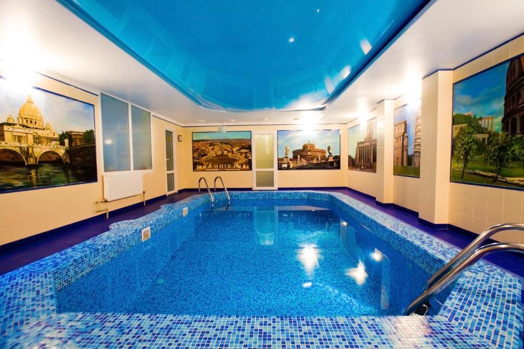 a large swimming pool in a room with paintings on the walls at Alexandrovsky Garden in Nizhny Novgorod
