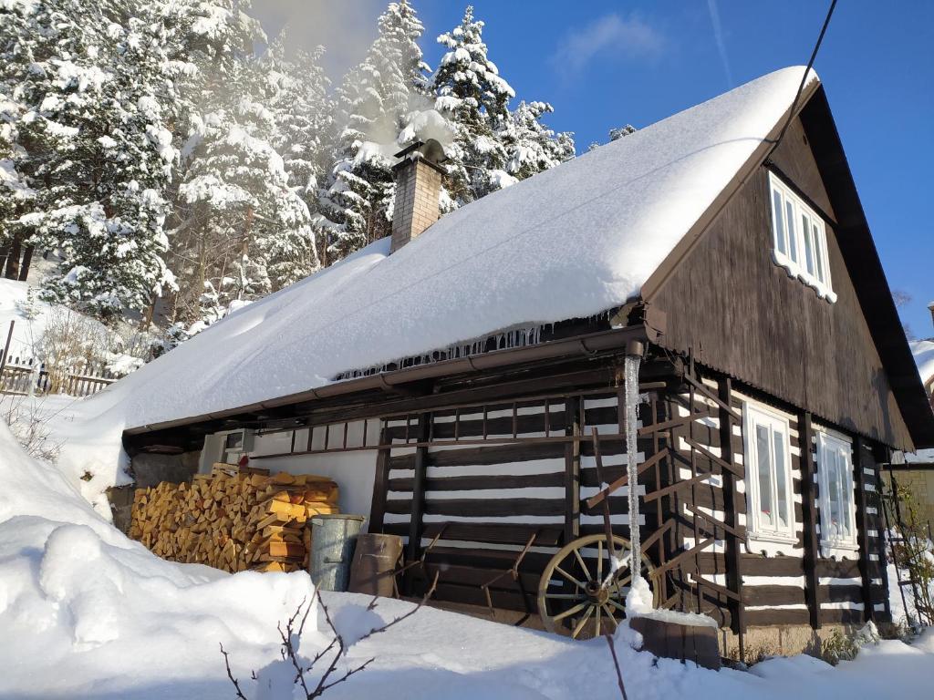 KoberovyにあるUbytování Roubenkaの屋根に雪を積んだ木造納屋