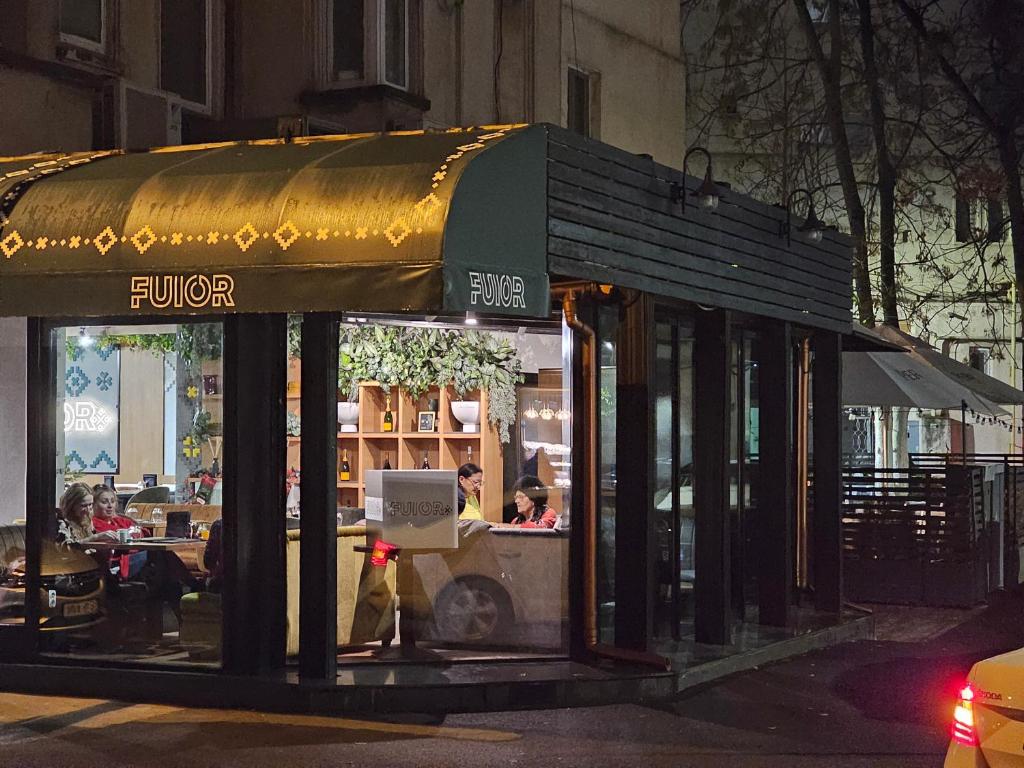 a restaurant with awning on a street at night at Private room at Ceausescu's place in Old City Unirii Square in Bucharest