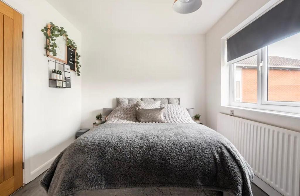 a bedroom with a bed and a window at BYRON SQUARE COTTAGE in Hucknall