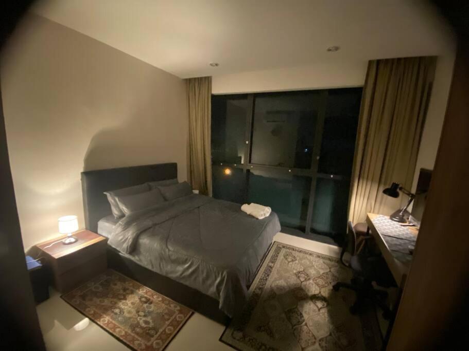 ein kleines Schlafzimmer mit einem Bett und einem Fenster in der Unterkunft Malina Cozy Suite 3.0 @Kozi Square in Kuching