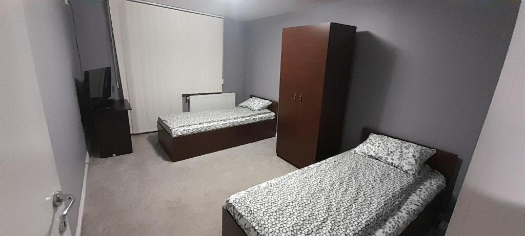 VulcanにあるDALLAS Apartament 31のベッド2台と鏡のある小さな部屋