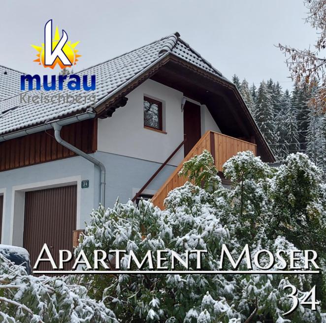 ein schneebedecktes Haus mit einem Schild darauf in der Unterkunft Apartment Moser in Lutzmannsdorf