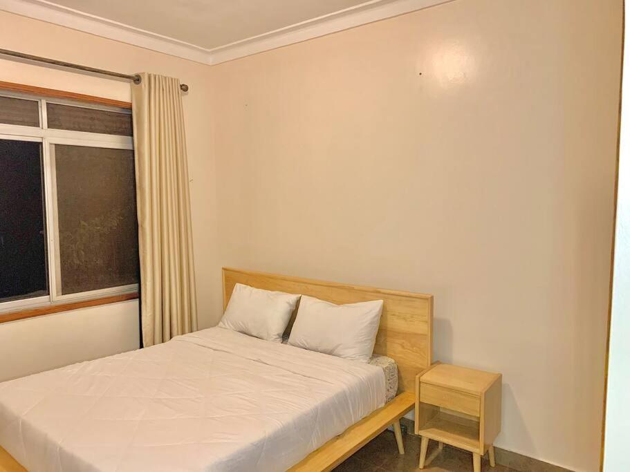 a small bedroom with a bed and a window at House in Kampala in Kampala