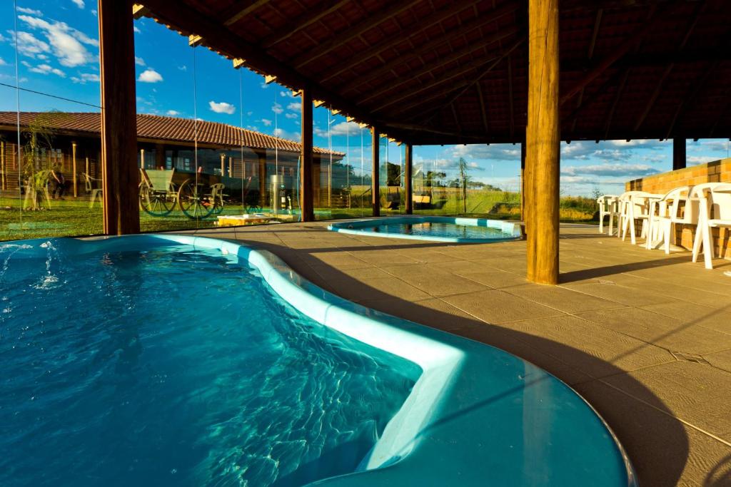 a swimming pool in a house with two pools at Apartamento na Fazenda c/ Piscina Termica in Palmeira