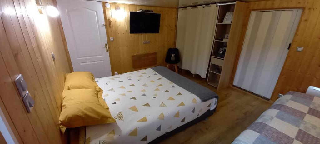 Dormitorio pequeño con cama y TV en Chambre d'hôte chez Nathalie & Roland, en Massiac