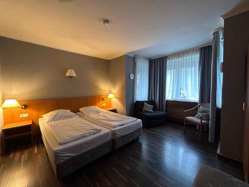 ein Hotelzimmer mit einem Bett und einem Stuhl in der Unterkunft WestEnd#106 in Frankfurt am Main