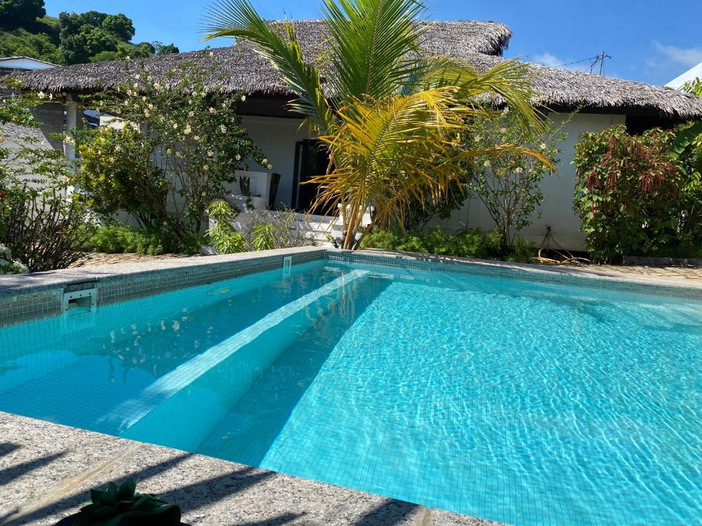 a swimming pool in front of a house at VILLABLANCA in Nosy Be