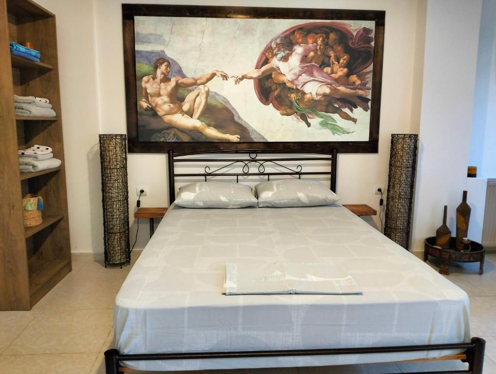 a bedroom with a large painting above a bed at Studio Melissi Korinthias in Melíssion