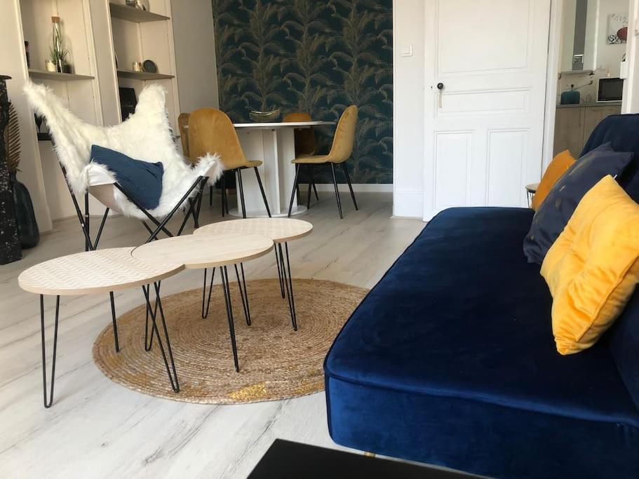 ein Wohnzimmer mit einer Couch und einem Tisch und Stühlen in der Unterkunft L'Ecrin de Lena in Épernay