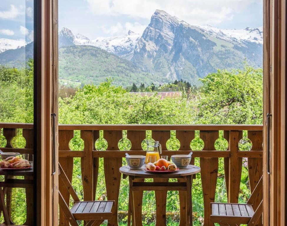 una mesa en un balcón con vistas a las montañas en Le Gypaète, en Morillon