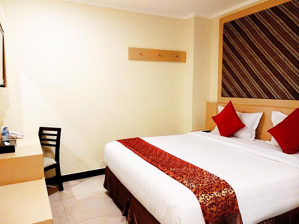 a hotel room with a bed and a desk and a chair at Jakarta City Hotel in Jakarta
