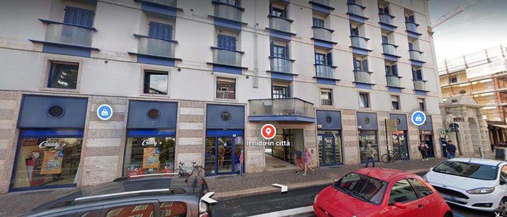 una calle con coches estacionados frente a un edificio en lL NIDO IN CITTÀ, en Trento