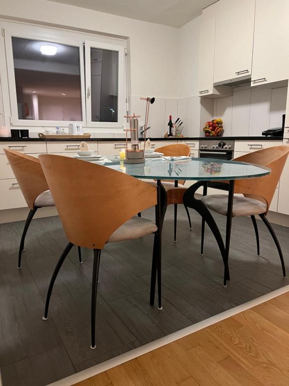 a glass table and chairs in a kitchen at Blessed home, feel at home in ZH in Zurich