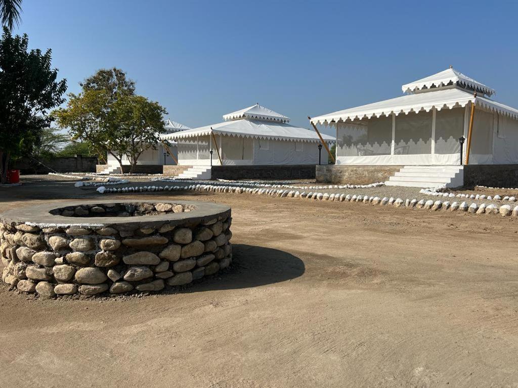 a stone fire pit in front of two buildings at jawai RIYASAT PANTHERA in Bāli