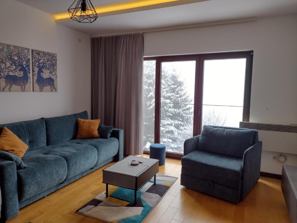 - un salon avec un canapé bleu et une chaise dans l'établissement Glecer A07, à Kopaonik