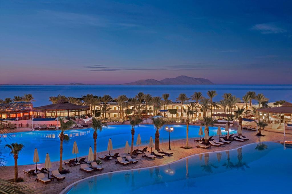 einen Luftblick auf ein Resort mit Palmen und Stühlen in der Unterkunft Sultan Gardens Resort in Sharm El Sheikh