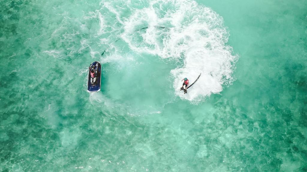 a person riding a wave on a surfboard in the water at Bandos Maldives in North Male Atoll