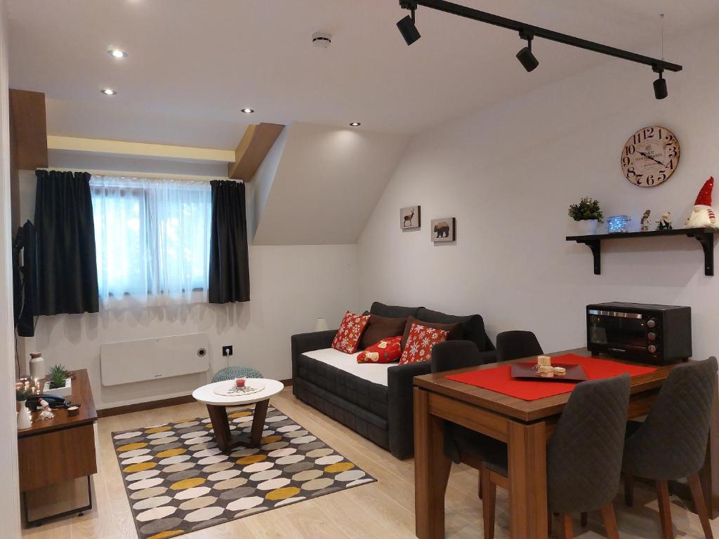 a living room with a couch and a table at Apartman M&S - Zoned 2 in Kopaonik