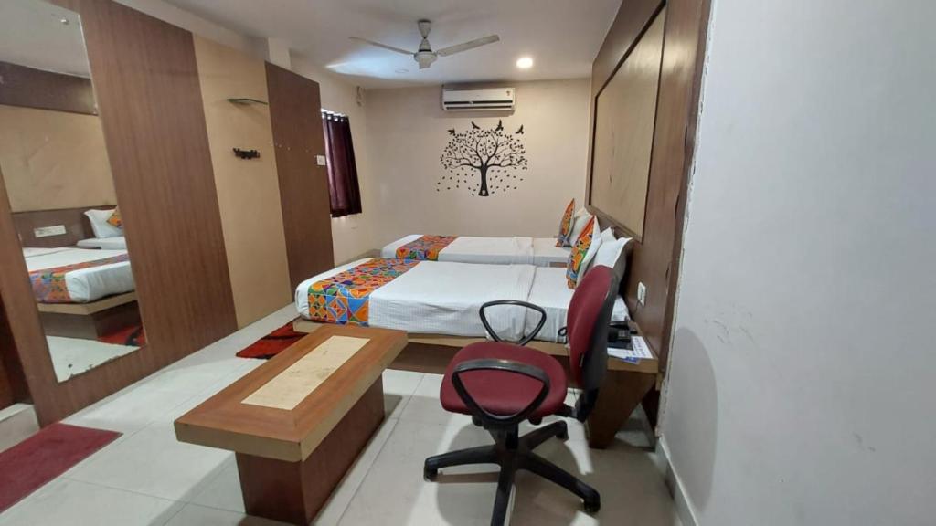 een slaapkamer met een bed, een bureau en een stoel bij Goroomgo Park Resort Bhubaneswar Near Railway Station Best Seller in Bhubaneshwar