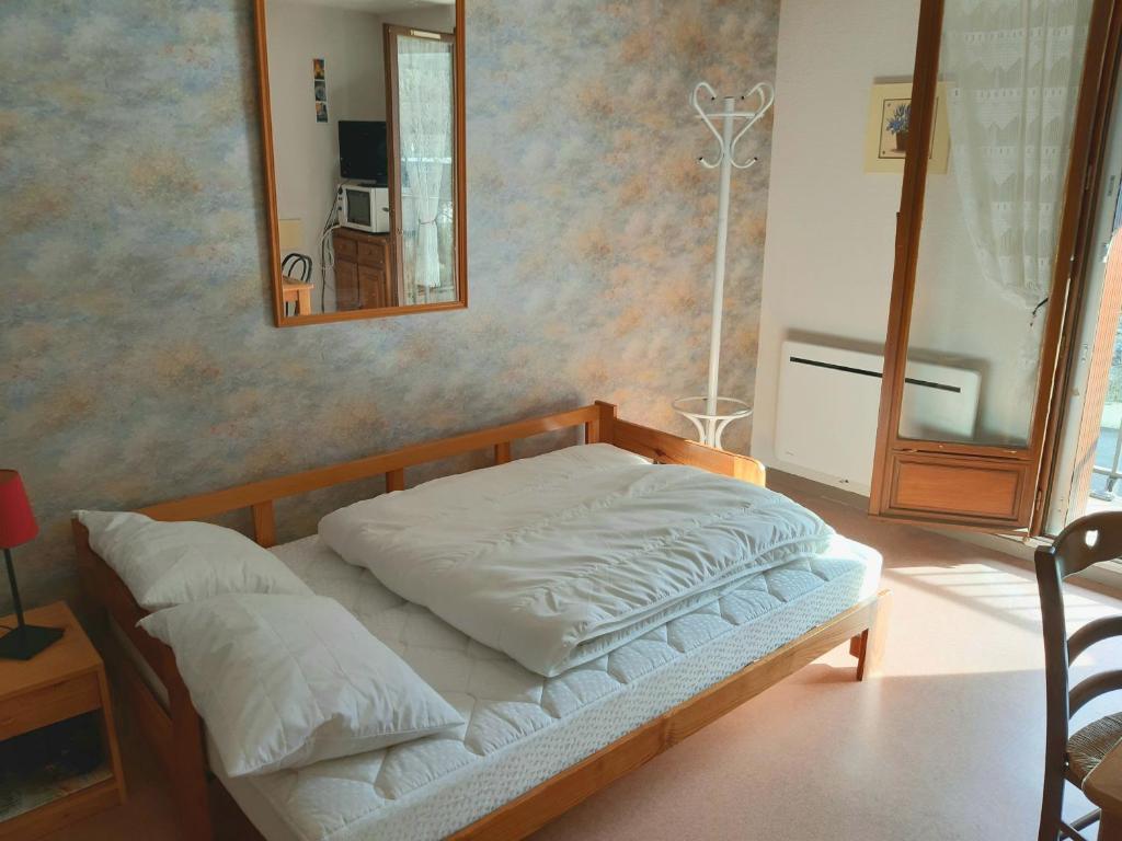 um quarto com uma cama com um espelho na parede em Studio Gavarnie em Gavarnie