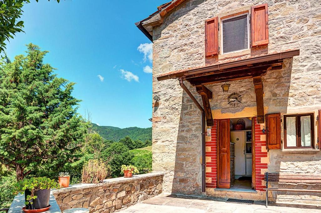 un edificio de piedra con un árbol delante de él en Poet's Rest, en Pieve Santo Stefano