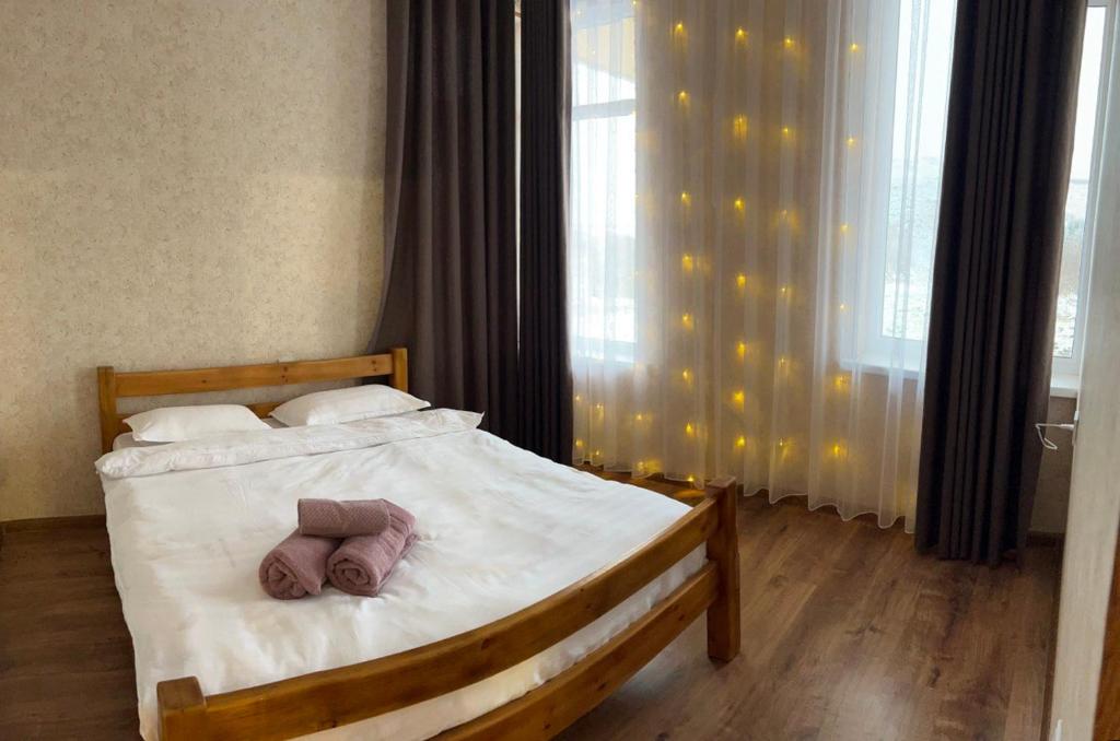 a bedroom with a bed with two towels on it at Домик у реки 