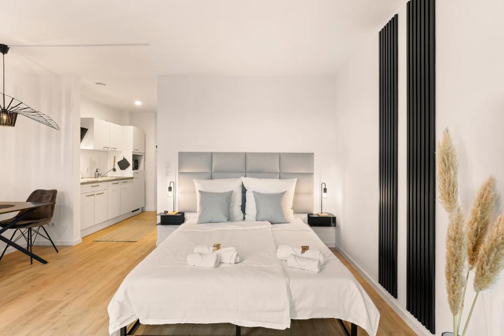 a bedroom with a large white bed with two towels at Modernes Apartment am Gleispark in Oldenburg